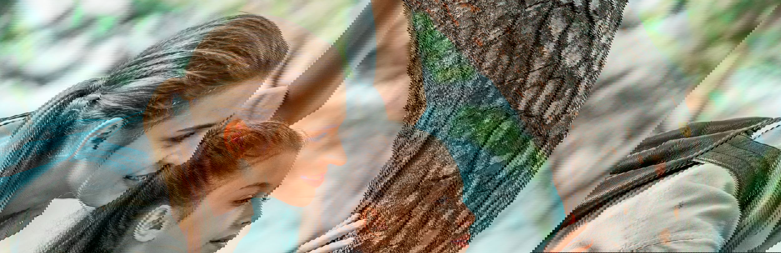 Mutter und Tochter halten sich am Baum im Sani Forest fest