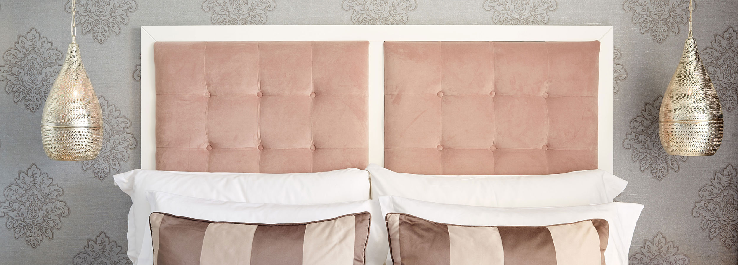 Primo piano del letto matrimoniale con cuscini a righe