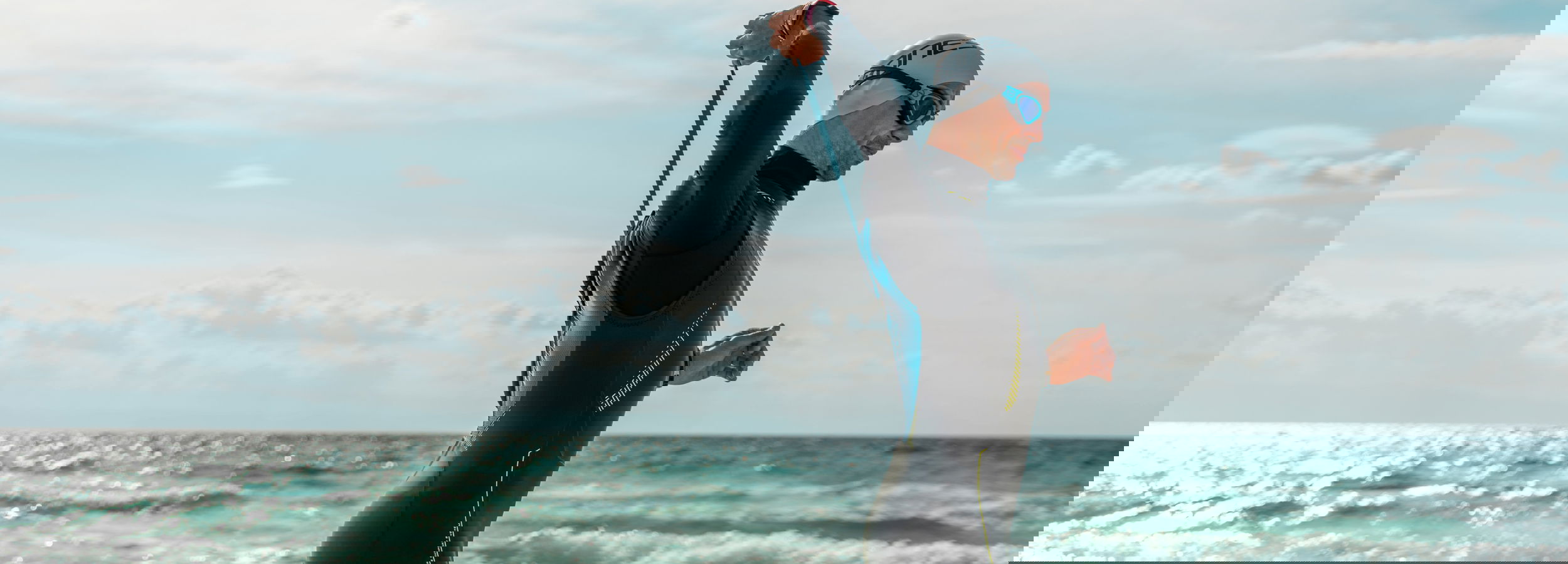 Mann in Neoprenanzug, der im Meer im Sani Resort steht