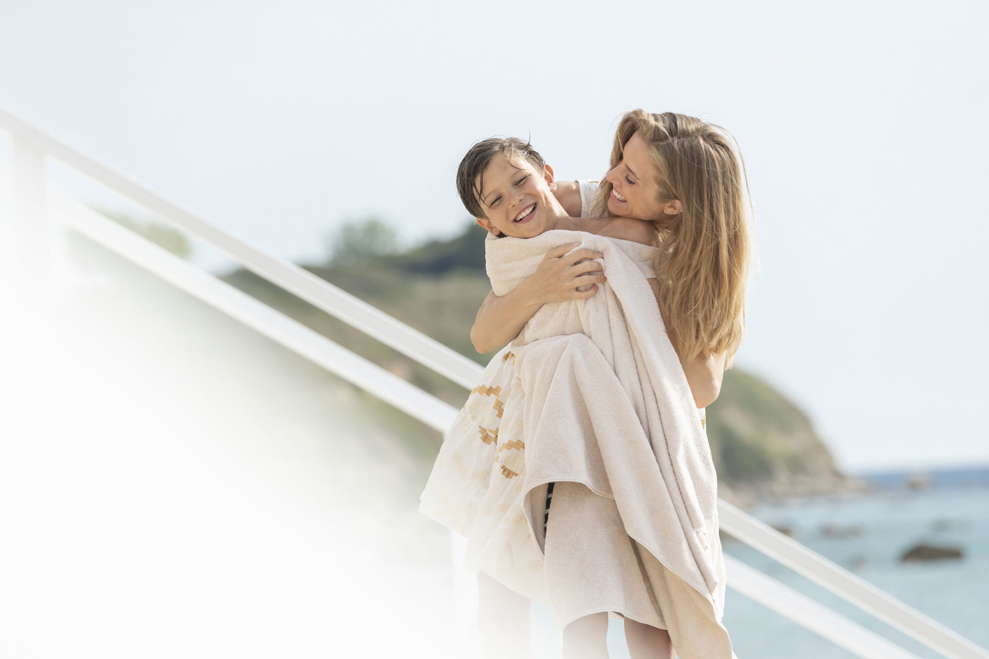 Μητέρα που αγκαλιάζει τον γιο της τυλιγμένο σε μια πετσέτα 