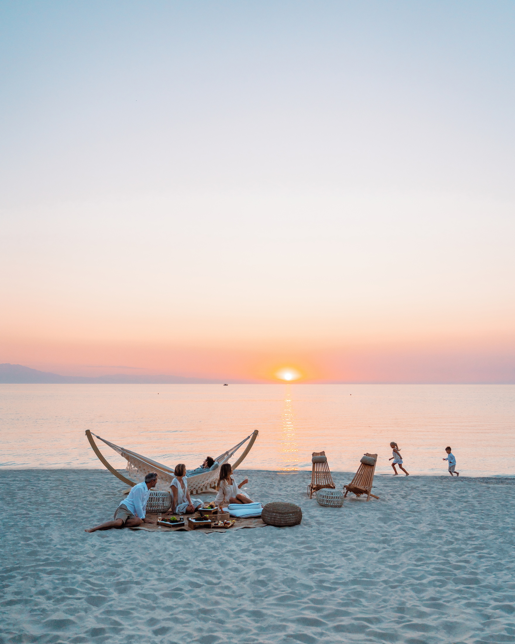 Famille sur la plage du Sani Resort au coucher du soleil 