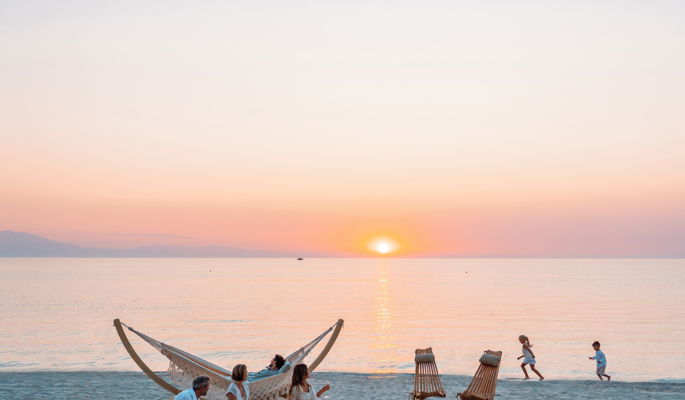 Familie am Strand im Sani Resort bei Sonnenuntergang