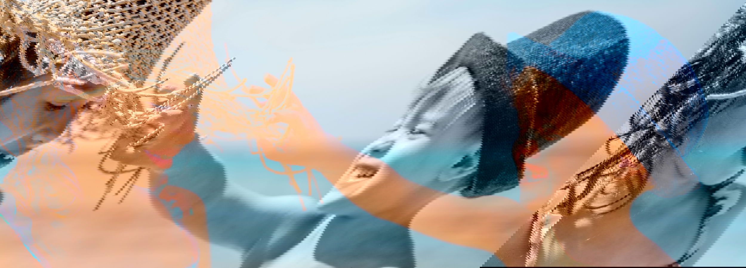 Αγόρι και κορίτσι με καπέλα για τον ήλιο που παίζουν στην παραλία