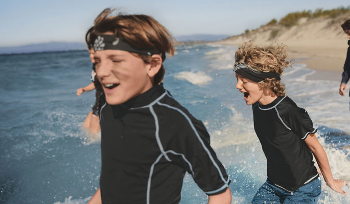 Woman walking next to pool against sea backdrop
