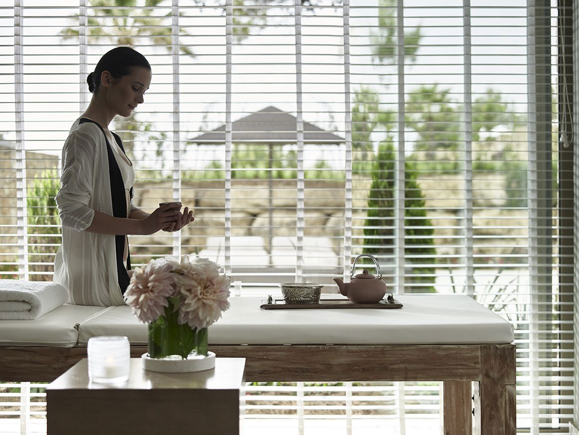 Dame buvant du thé sur un lit de massage