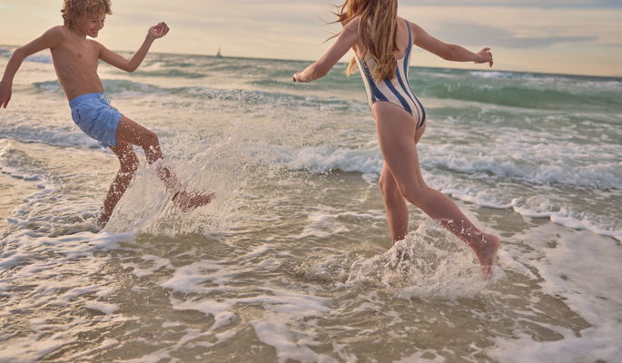 Madre e figlia che si allontanano dal mare all'ora d'oro