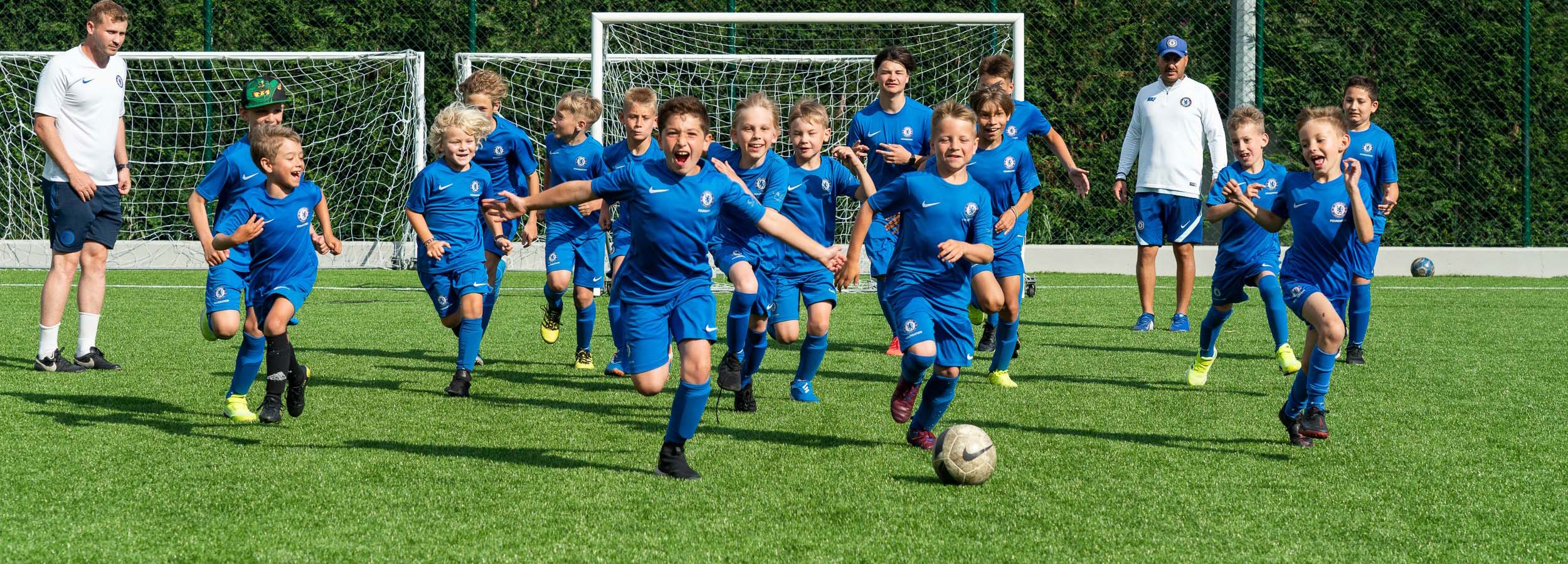 Petits garçons courant sur le terrain de la Footbal Academy