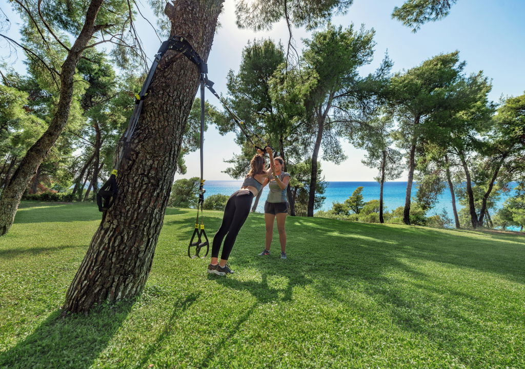 Женщина делает растяжку с помощью лент