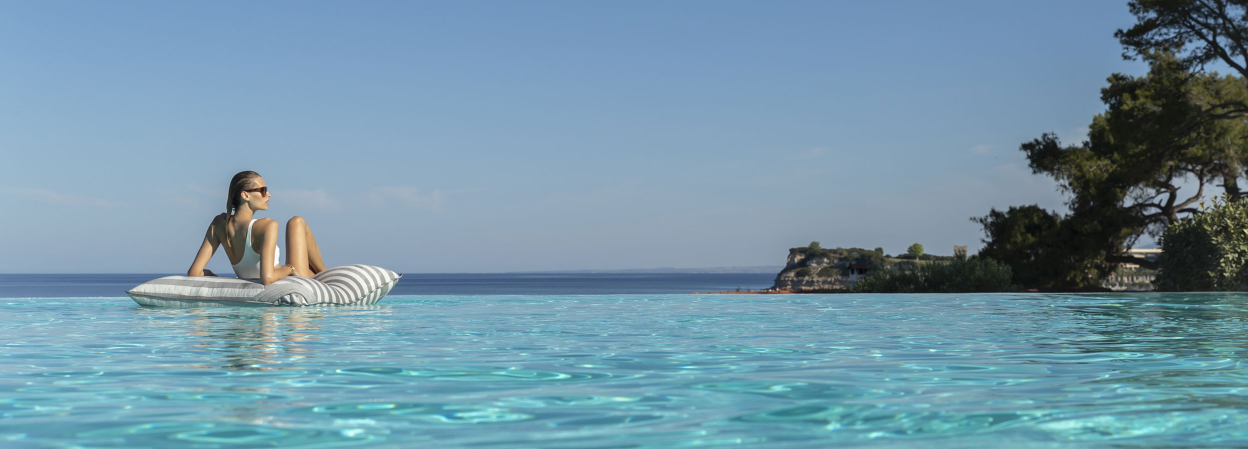 Woman relaxing on a float in an infinity pool
