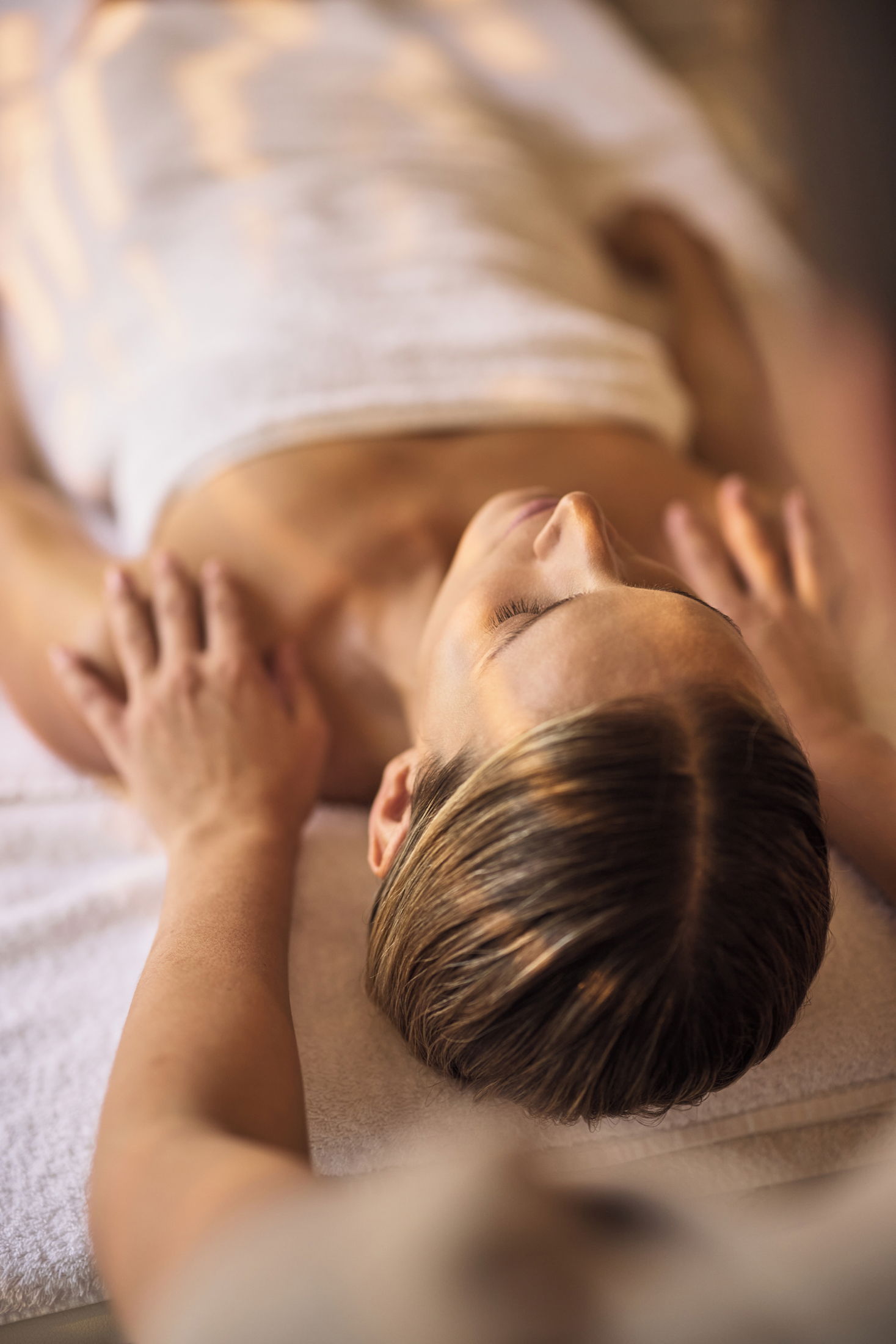 Woman laying down on massage chair at Sani Spa