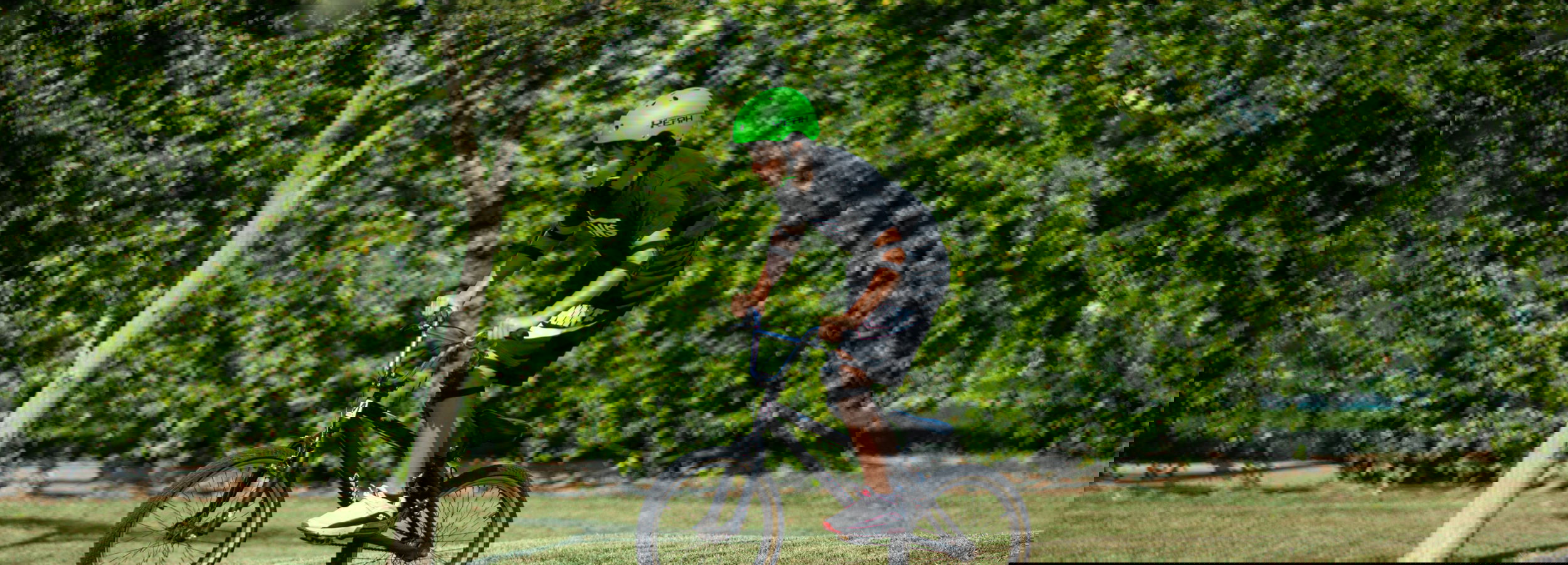 Homme plaçant un casque sur la tête d'un petit garçon à la Biking Academy