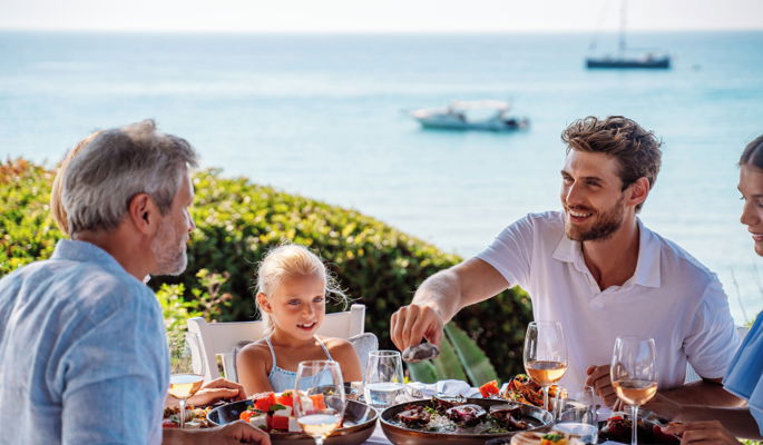 Famiglia che si gode una cucina di classe mondiale in un ristorante all'aperto at Sani Club