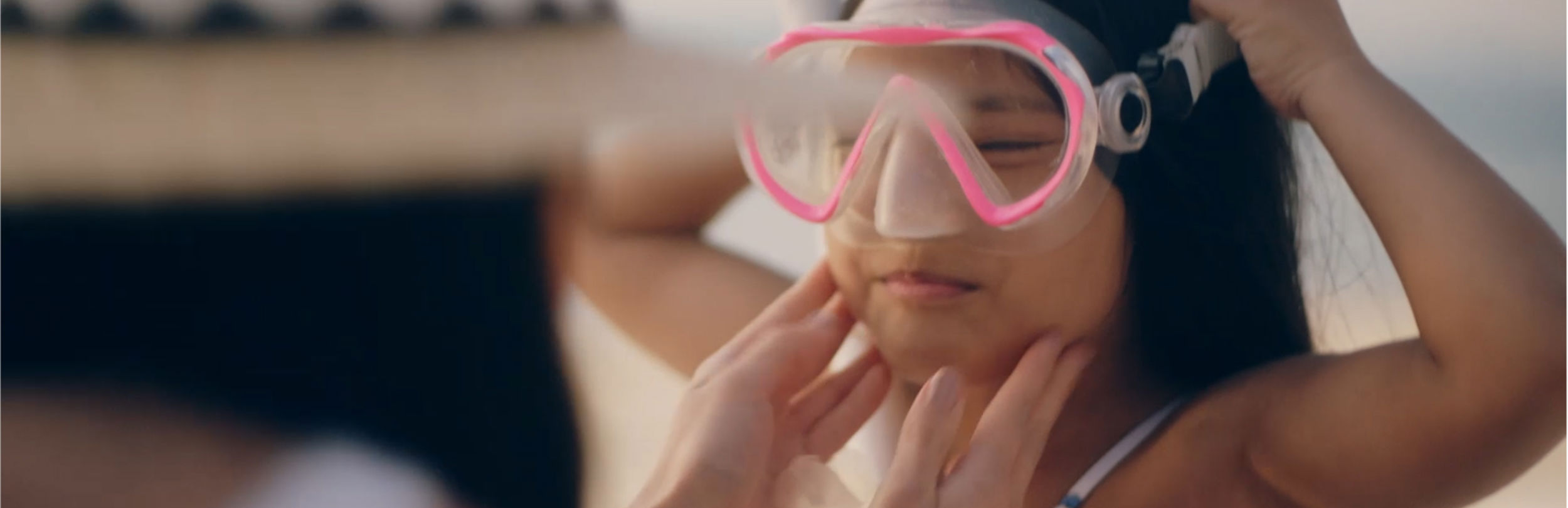 Mädchen legt Schnorchel am Strand an