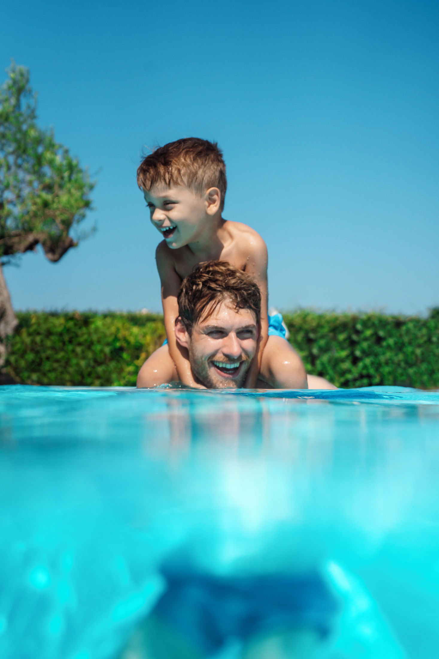 Vater und Sohn spielen im Pool