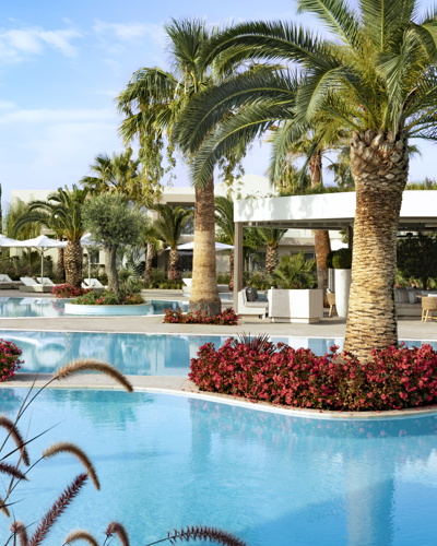 Mutter und Tochter auf Sonnenliege neben dem Pool