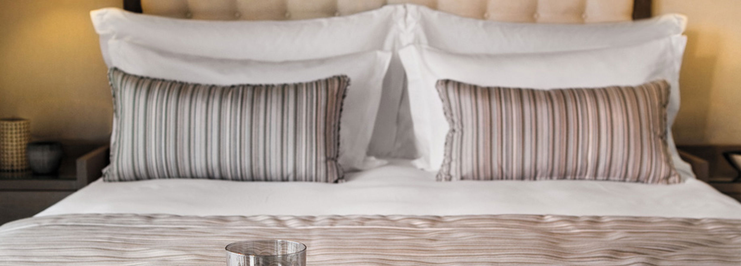 Close up of double bed with striped cushions