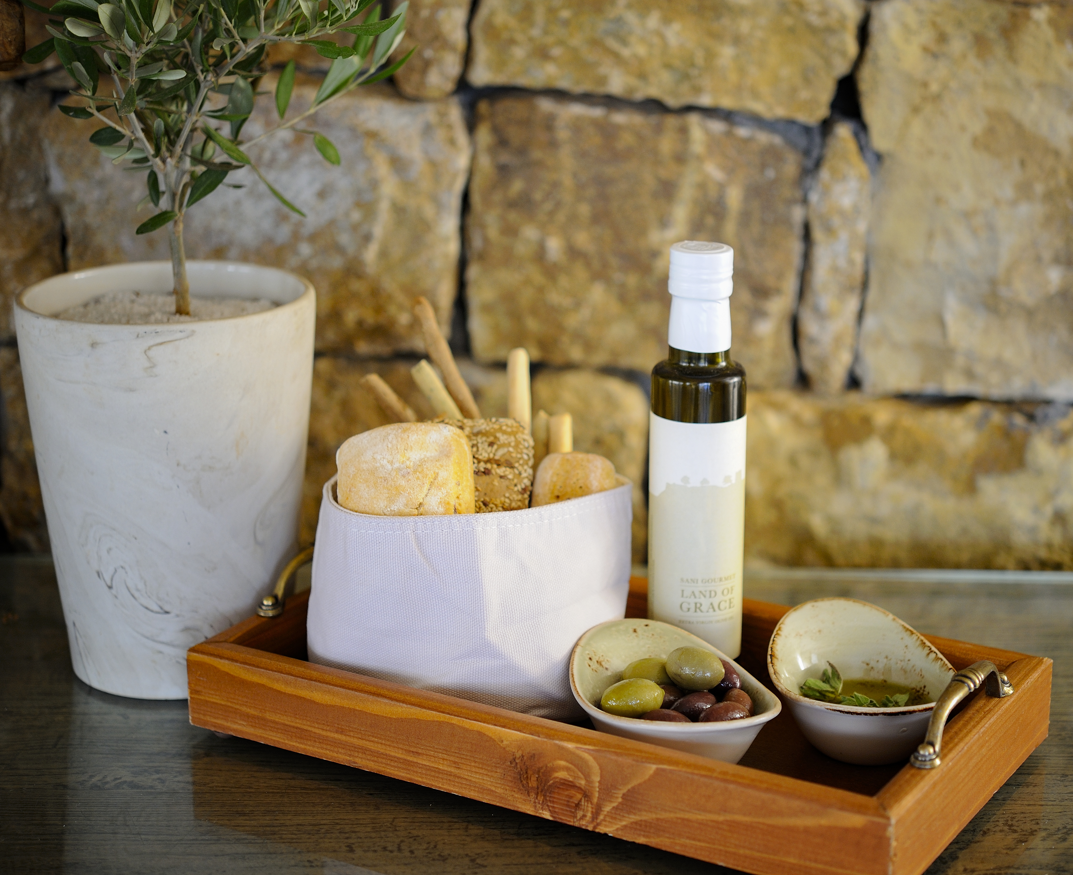 Tomato and feta salad on bed of tomatoes and bowls of olives