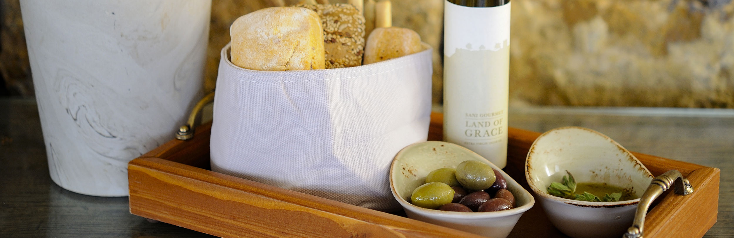 Tomato and feta salad on bed of tomatoes and bowls of olives