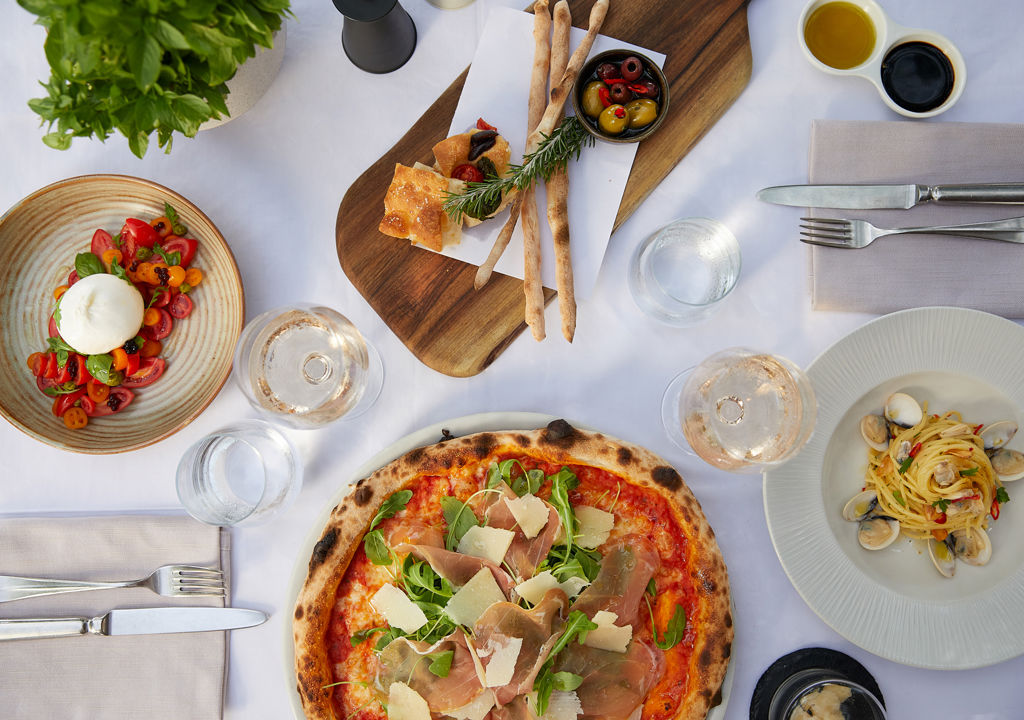 Pizza, linguine and tomato salad dish